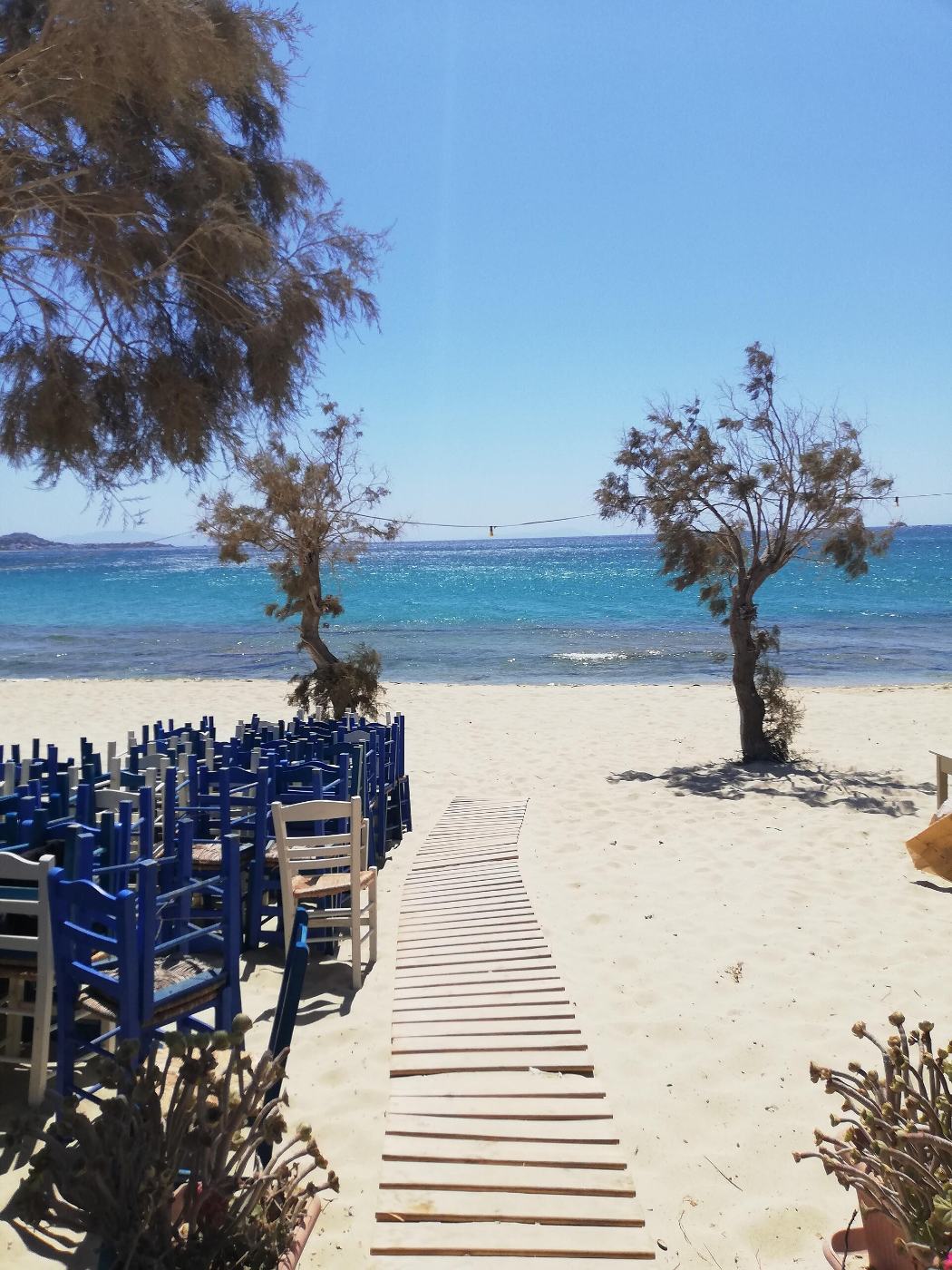 The boardwalk down to Plaka beach, past the taverna tables