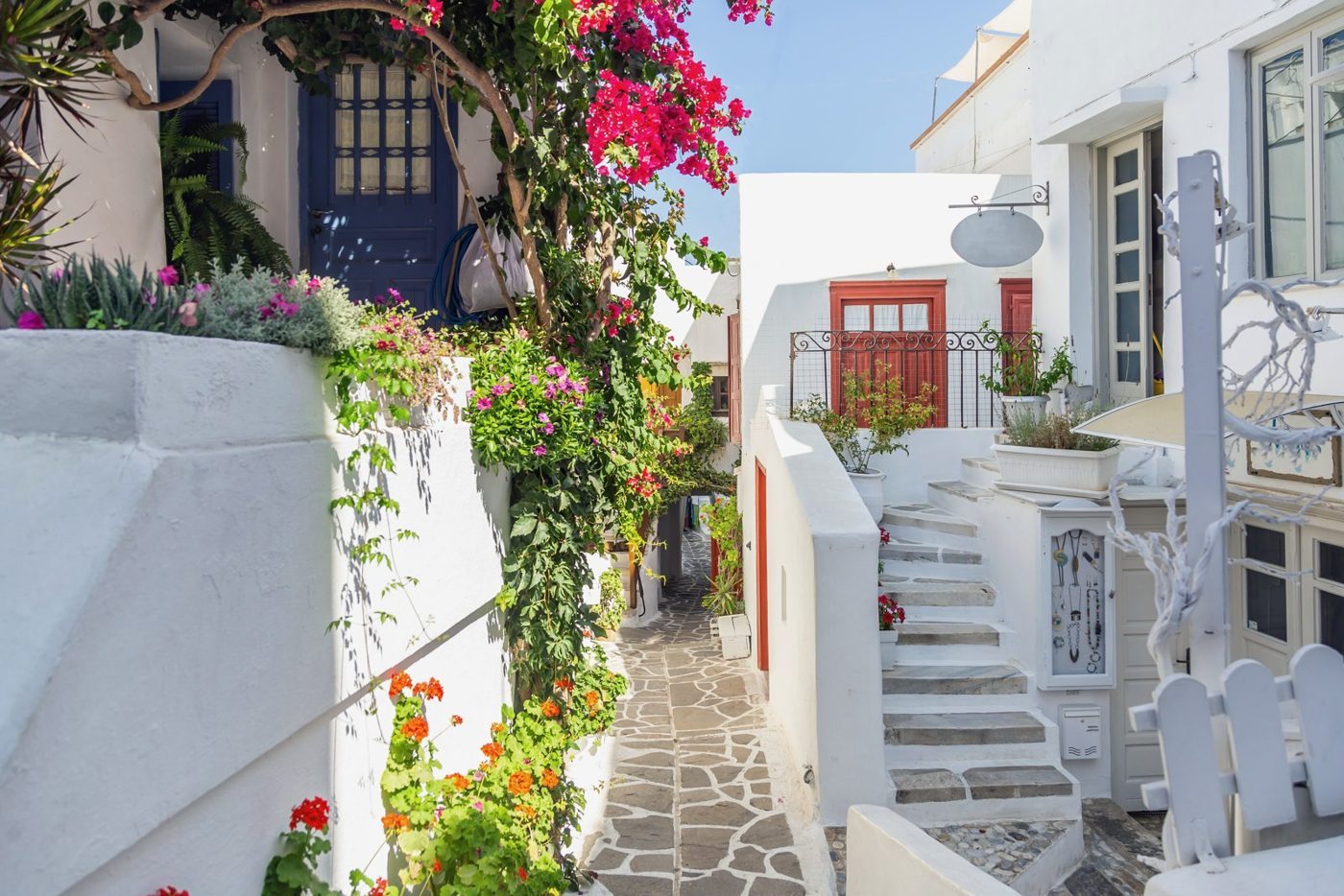 Bougainvillea and whitewashed houses in a paved alley of Naxos town