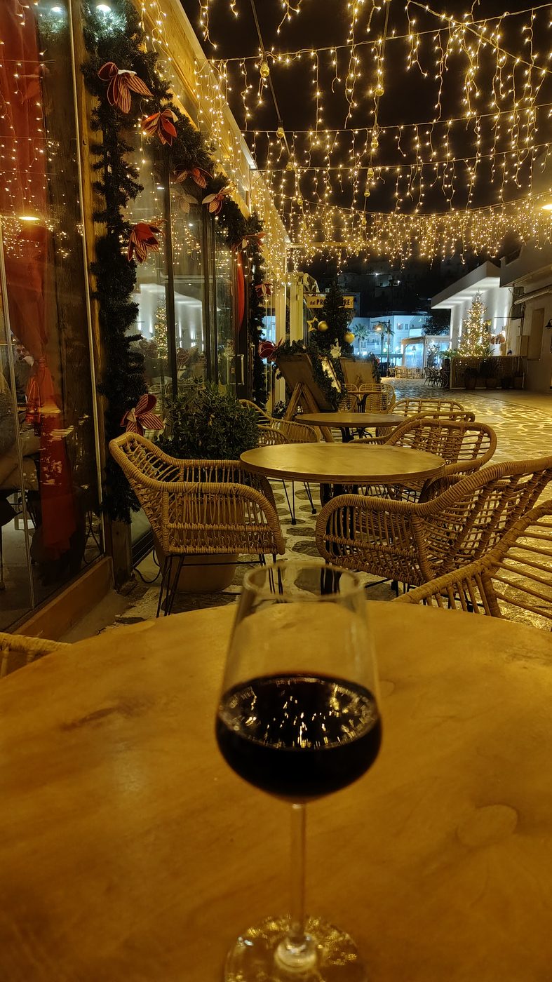 Café tables under fairy lights on the Naxos waterfront
