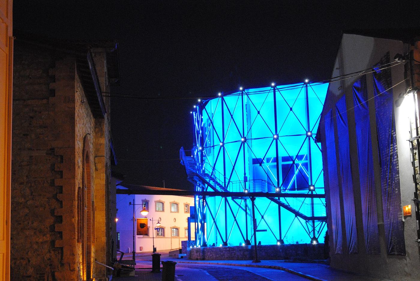 The gasholder glowing blue at night